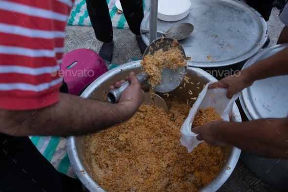 Distributing biriyani rice to people during break fast at Ramadan times in Abu Dhabi, U.A.E.