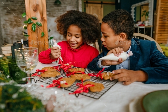 Sister And Brother Decorating Christmas Gingerbreads With Ribbons At ...