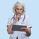 Portrait of thoughtful aged woman doctor with tablet pc. - PhotoDune Item for Sale