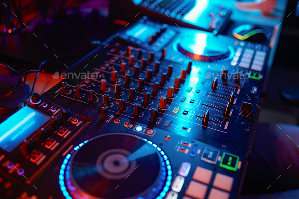 Closeup on dj turntable mixer in neon light