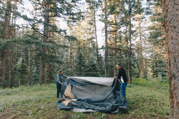 Older couple setting up a tent in the wilderness Stock Photo by takemewu31