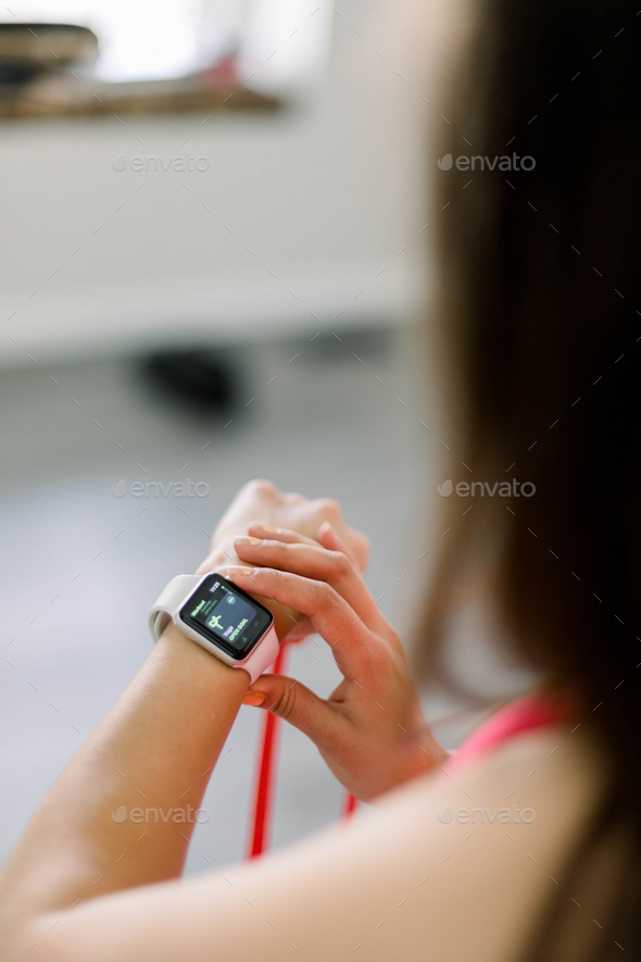 Woman checking her Apple Watch after a workout  - Stock Photo - Images
