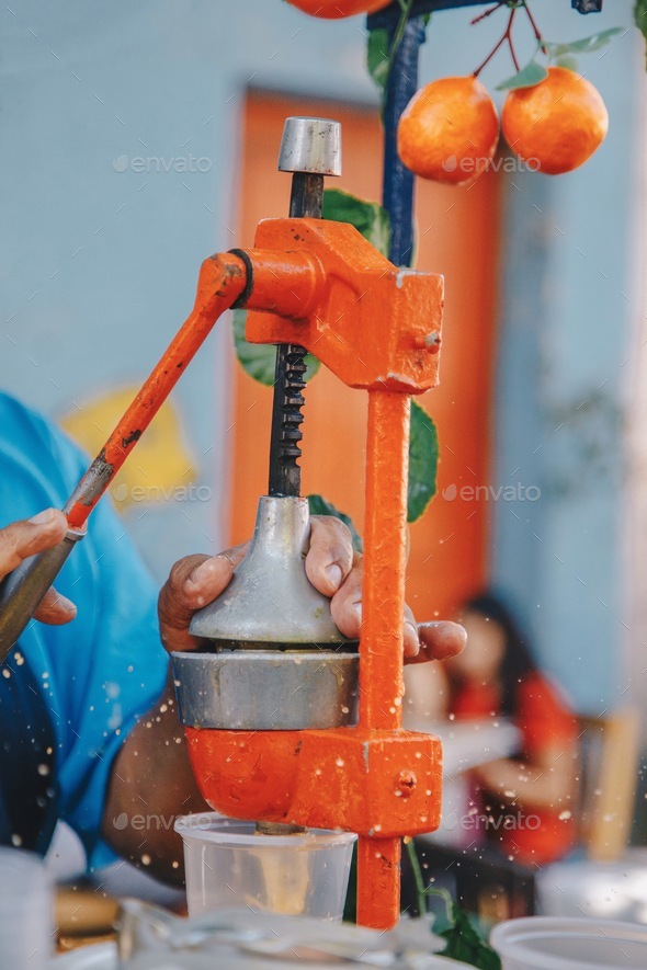 Man squeezing oranges to make orange juice Stock Photo by takemewu31