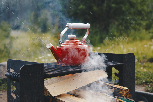 Heating up water in a red kettle at a campsite