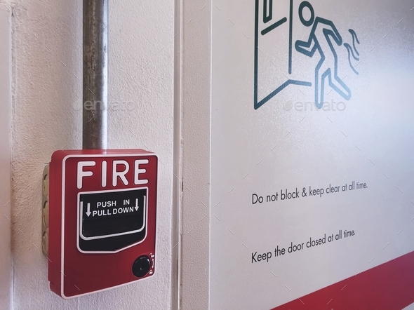 Close-up Red Fire Alarm Box Near Emergency Fire Exit Door