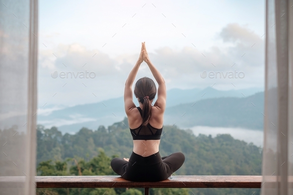 Young woman doing Yoga and stretching muscle in morning, healthy girl meditation against mountain