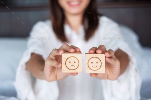 Woman holding smile and angry emotion face block. Customer choose Emoticon for user reviews.