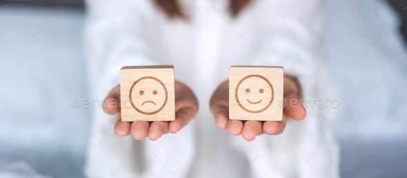 Woman holding smile and angry emotion face block. Customer choose Emoticon for user reviews