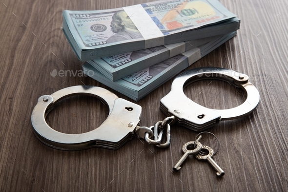 Money and handcuffs. Concept for corruption, fraud and money laundry