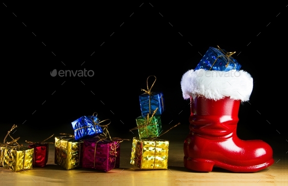 Red Santa boot and gifts on black background Stock Photo by tehcheesiong