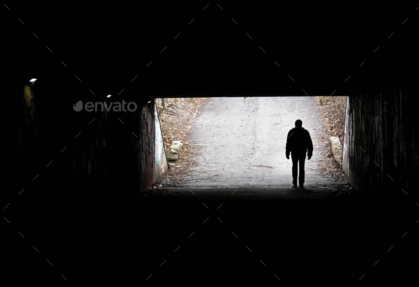 Silhouette of a man in the darkness of the tunnel