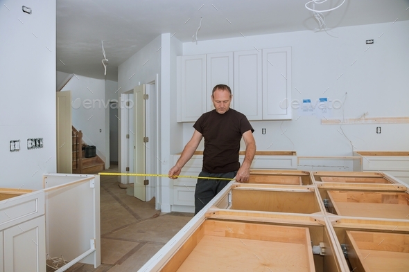 Man using tape measure for measuring on kitchen in furniture for home improvement.