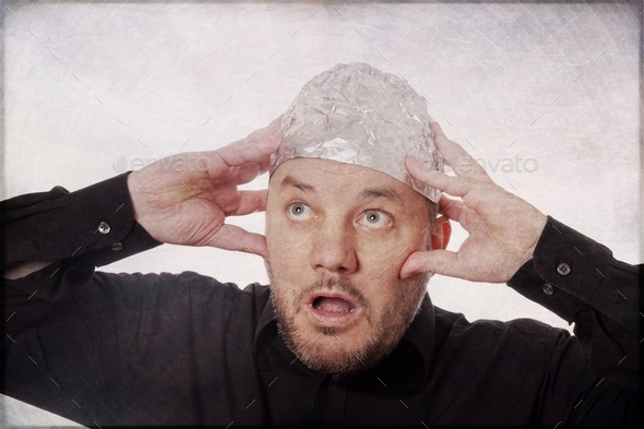 paranoid man with tin foil hat - conspiracy theories