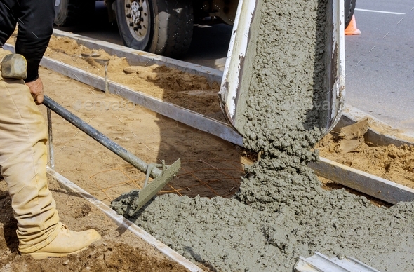 Concrete being poured from a mixer truck into a concrete with sidewalk ...