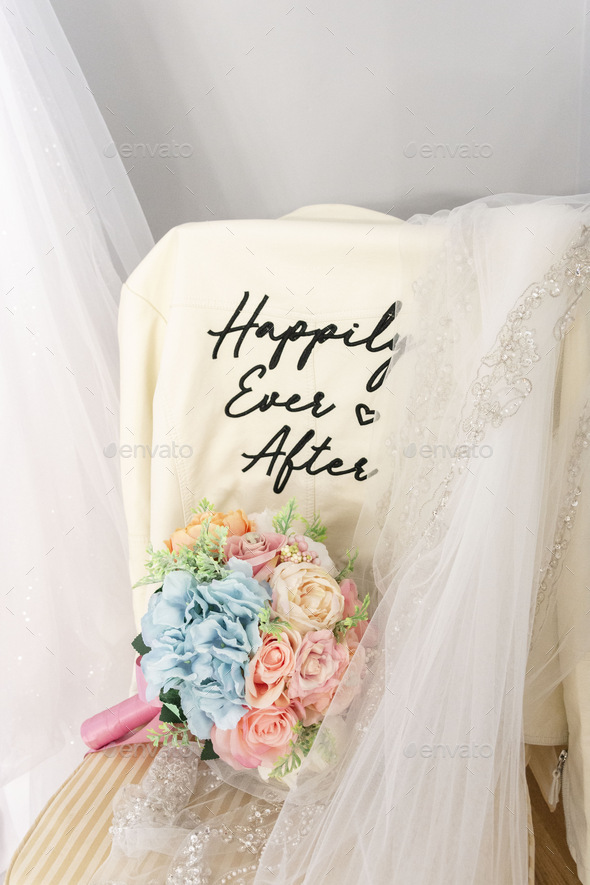 Bridal bouquet and a leather jacket with text saying “happily ever after”