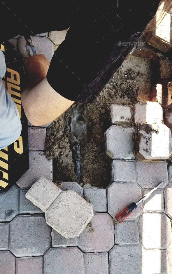 Water Leak! A man repairs an underground sprinkler system! Stock Photo
