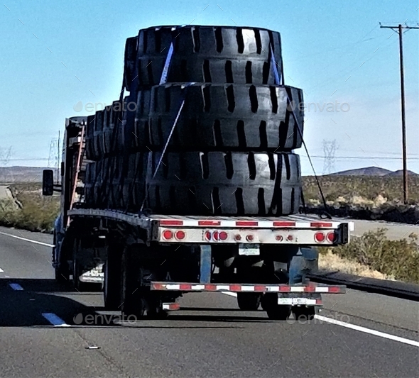 Transportation and Logistics! BIG Oversized Tires Hauled on a Flat Bed Trailer!