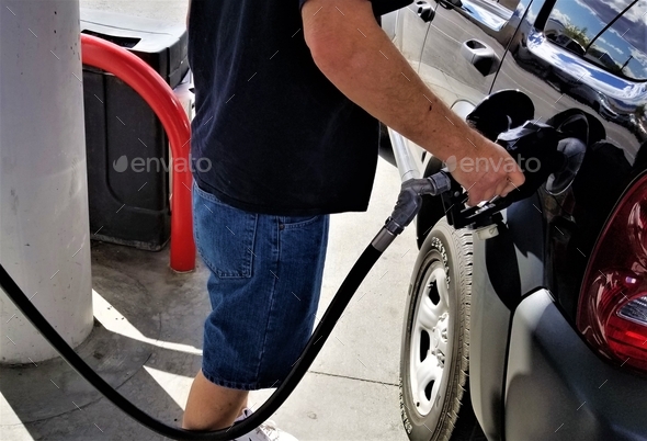 Gas and Oil! A man refuels his car at the gas pump at the gasoline station. NOMINATED!!