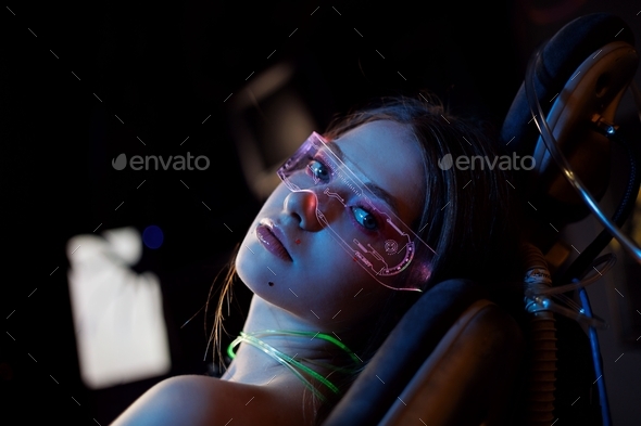 Cosplay girl in transparent glasses with elf ears in coloured light. Fairy tale portrait