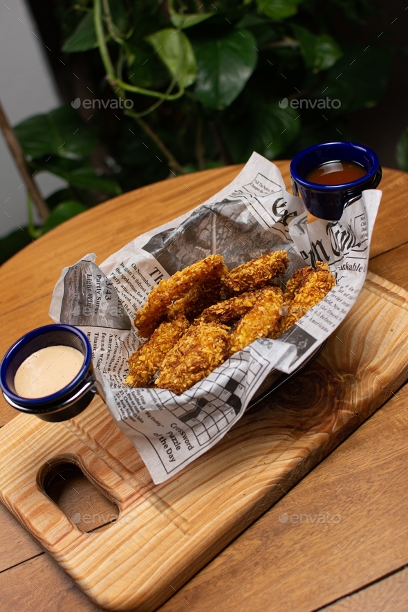 Fried chicken basket. crispy chicken News paper. chicken with sauces
