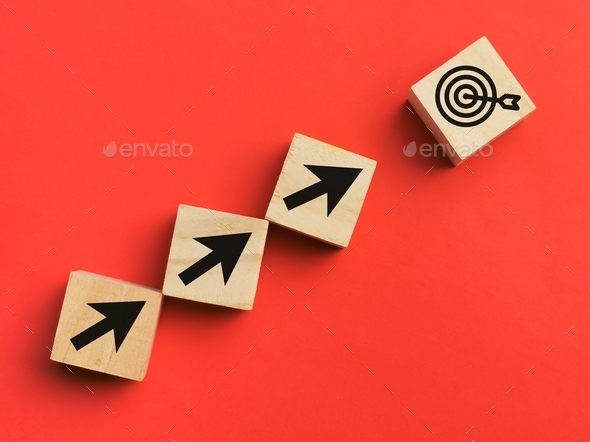 A bunch of wooden cubes line upward with arrow and dart target