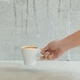 Female barista places a coffee cup on the table to serve the customer. - PhotoDune Item for Sale