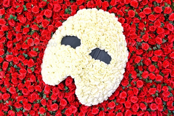 Marquee Phantom of The Opera White Rose Mask on a bed of fresh cut red beaucoup red roses