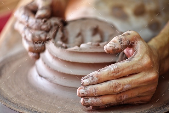 Unrecognizable clay pottery master craftsman at work