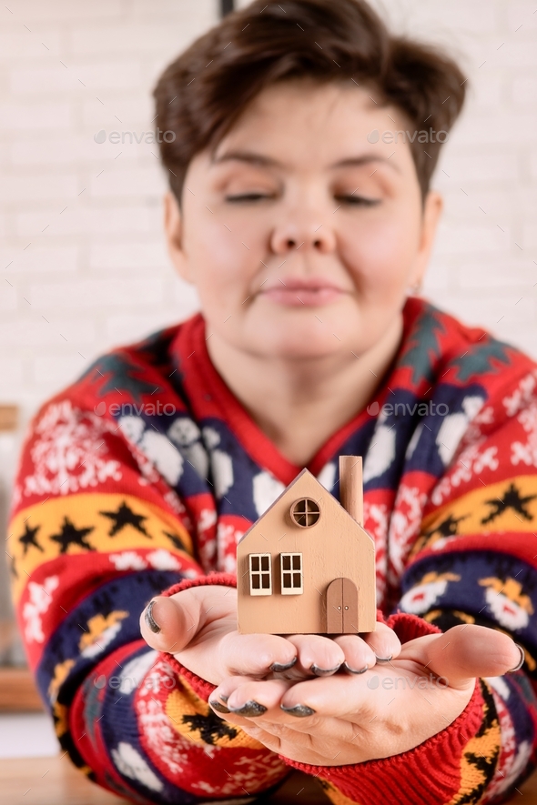 A woman holds a toy house in her hands.  - Stock Photo - Images