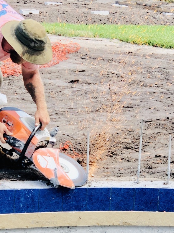 Construction worker cutting the rebars off with a cutoff saw. Stock