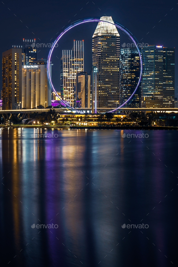 City vibes! View of Singapore Flyer and Marina Centre skyscrapers at night.