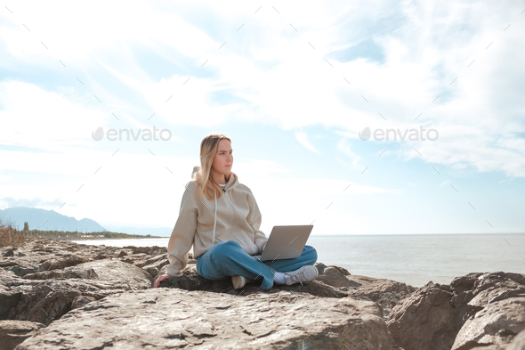 Remote work.Girl freelancer works remotely on the sea shore. workation, remote work,WFVH,Van Life