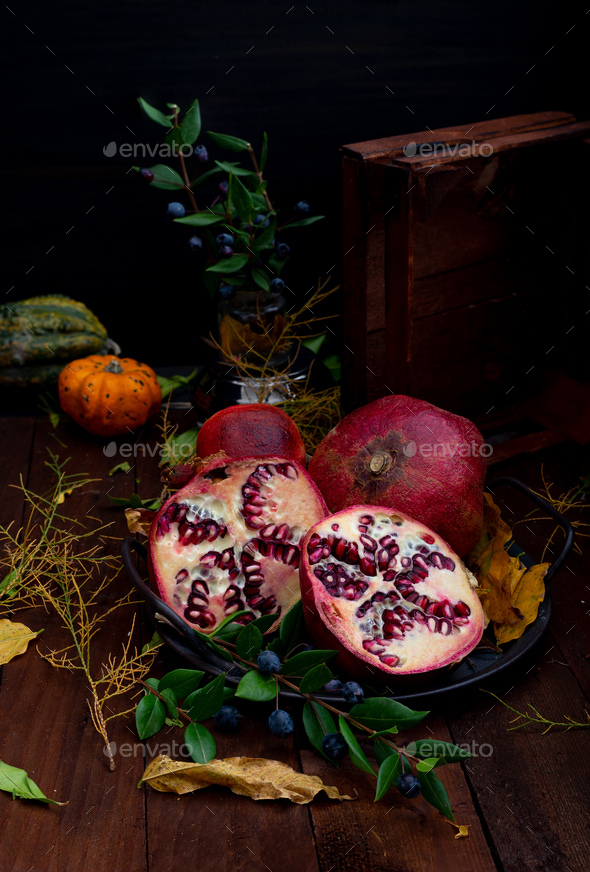 wooden basket with pomegranates and various props - Stock Photo - Images