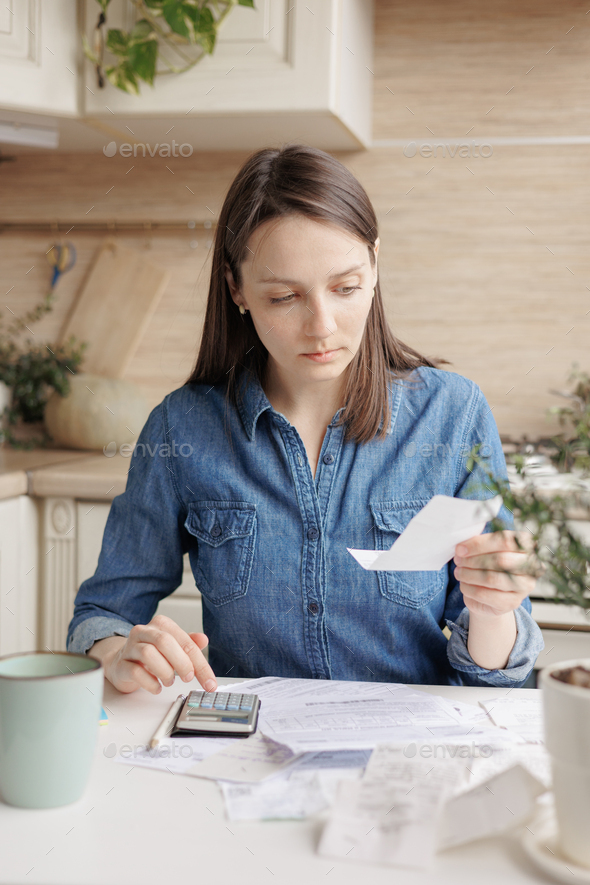 woman pays utility bills and writes checks. a European woman at home makes a calculation of expenses