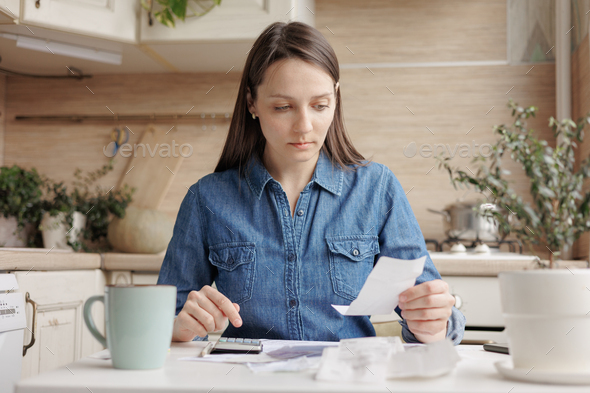 woman pays utility bills and writes checks. a European woman at home makes a calculation of expenses