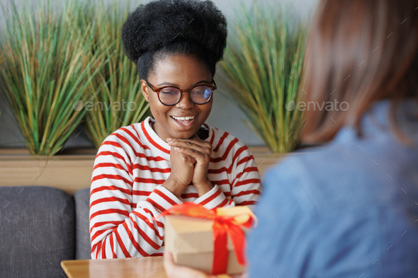 african American woman gives or receives a gift. a happy millennial woman with a cardboard box