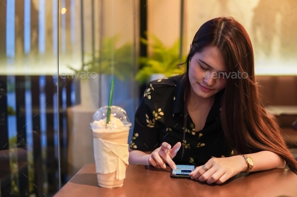 women use social media by smartphone in the cafe