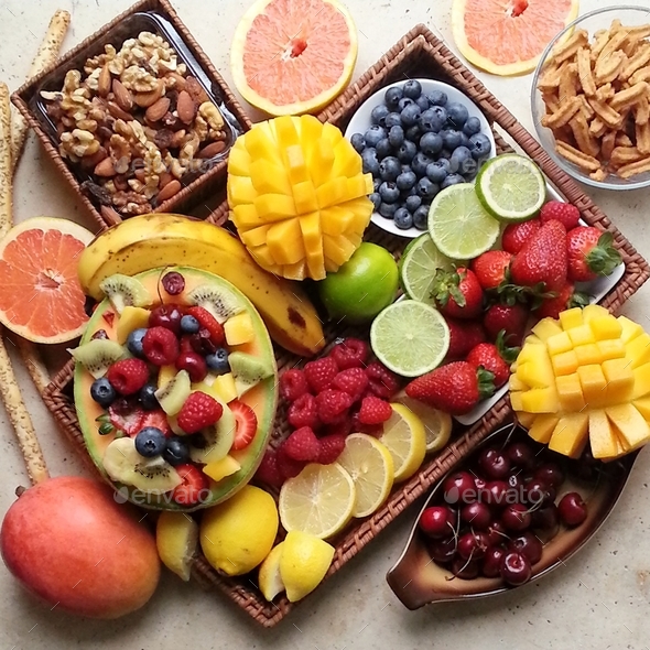 healthy food grazing platter on stone table made with fresh fruit and mixed nuts