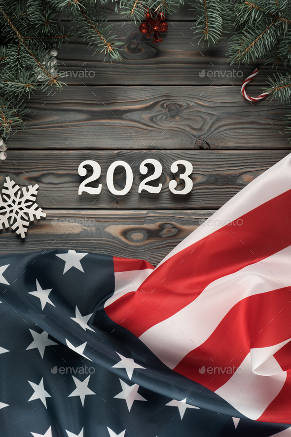 Vertical dark wooden wallpaper with American flag 2023 and Christmas toy frame. Happy new year