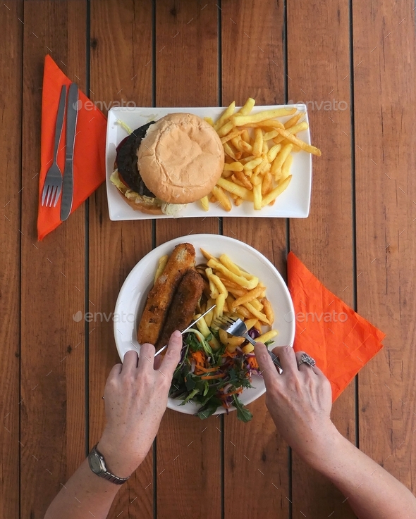Overhead view of person holding cutlery eating food,top view,table top