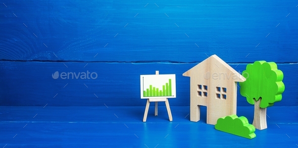 Residential building and easel with green positive upward trend chart