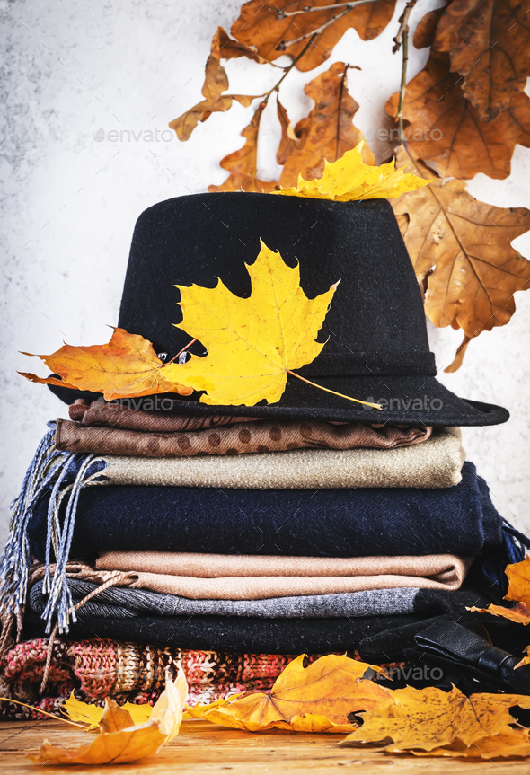 Cozy autumn background with warm autumn and winter clothes, scarves, sweaters, felt hat, gloves