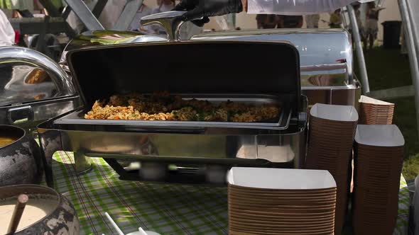 Different Delicious Food in Metallic Containers and Cauldrons.