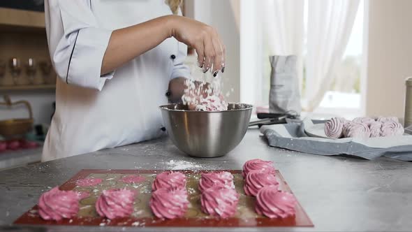 Female Chef Decorating Marshmallow Using Powdered Sugar in the Stylish Kitchen alt