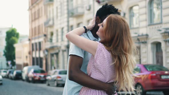 Happy Young Couple in Love Hugs on the Street in the City on a Summer Day alt