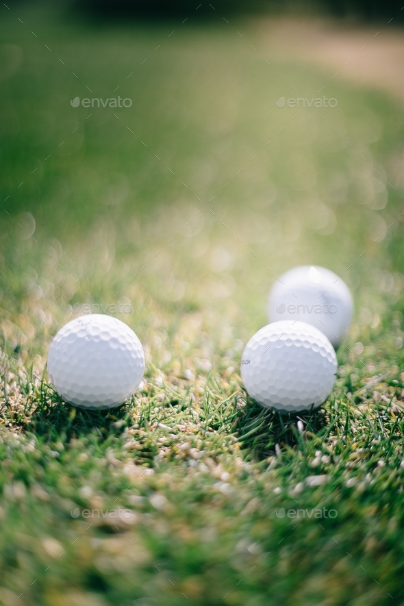 Golf balls on grass on sunny day. - Stock Photo - Images