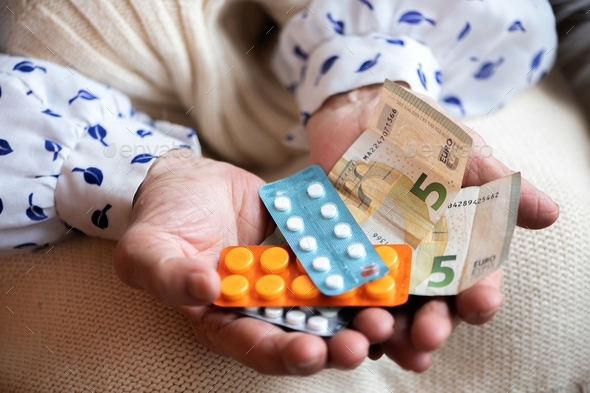 Many pills and euros money in senior woman hands. Painful old age. Caring for health of the elderly
