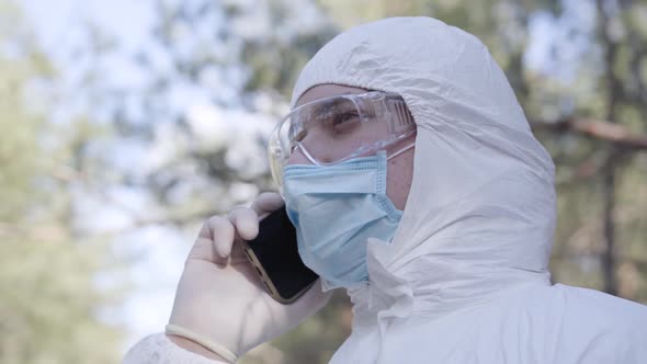 Close-up Side View of Young Caucasian Man in Safety Suit, Protective Eyeglasses and Face Mask alt