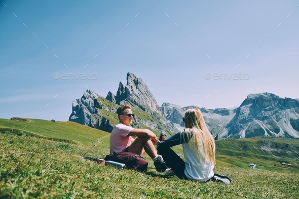 Hiking couple taking a break in front of epic mountain range  - Stock Photo - Images