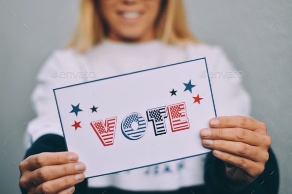 Female voter holding statement saying “vote”